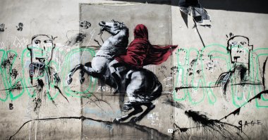 A recent artwork by street artist Banksy of Napoleon Bonaparte wearing a headscarf inspired by the original painting by Jacques-Louis David, Paris, France, June 26, 2018. (Photo by Getty Images)