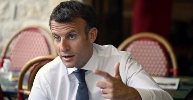 French President Emmanuel Macron speaks and gestures in a cafe during a visit in Saint-Cirq-Lapopie, near Cahors, southwestern France, June 2, 2021. (AFP Photo)