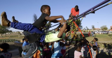 Children play on a swing at the newly built Meadowlands Park in Soweto, South Africa, Sept. 2, 2015. (AP Photo)