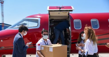 People unload boxes of vaccines from an airplane in an unknown location in North Macedonia in a photo shared by the country's Health Minister on his Facebook account, North Macedonia, June 9, 2021. (AA PHOTO)