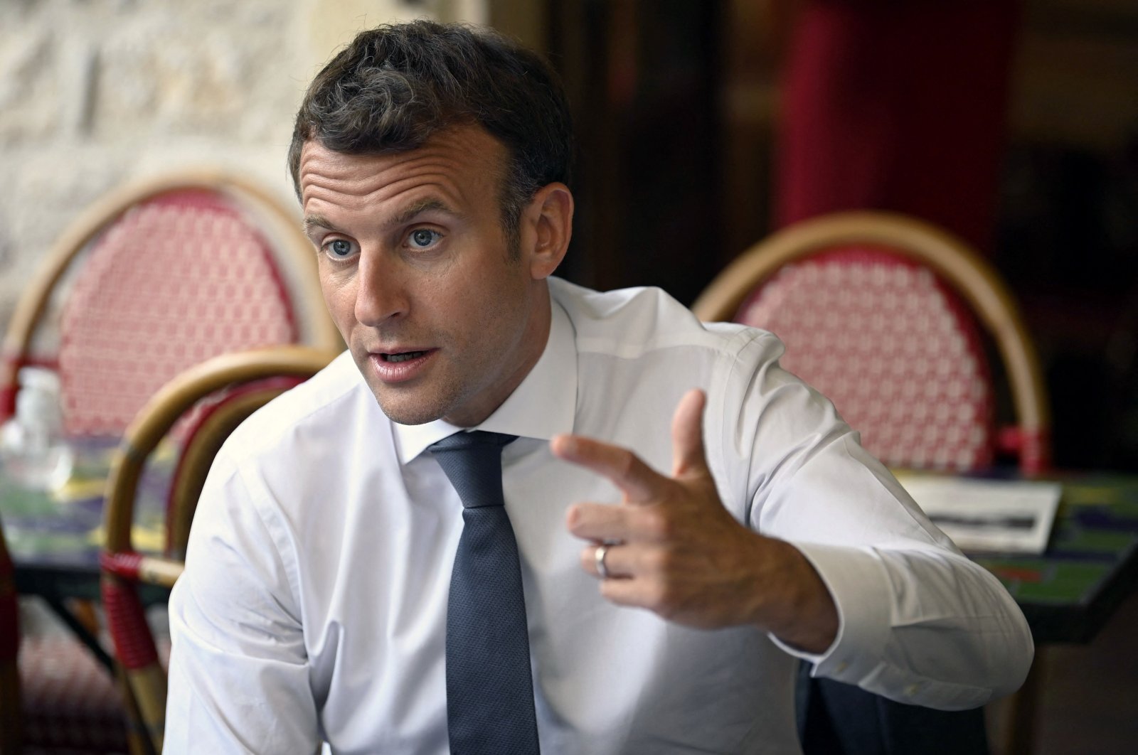French President Emmanuel Macron speaks and gestures in a cafe during a visit in Saint-Cirq-Lapopie, near Cahors, southwestern France, June 2, 2021. (AFP Photo)
