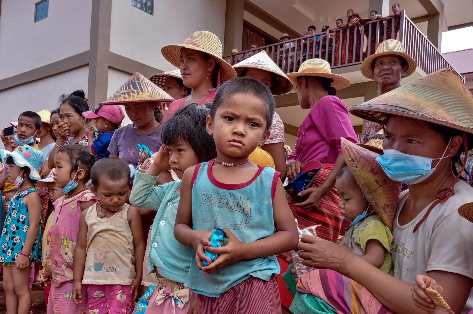Children and elders displaced from recent fighting between government troops and ethnic rebels in their area, wait for food distribution from a volunteer group while taking refuge at a monastery in Namlan town, in Myanmar's eastern Shan state, May 25, 2021. (AFP Photo)
