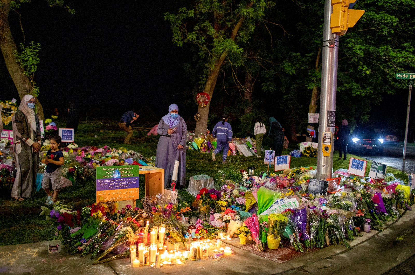 People gather at a makeshift memorial at the fatal crime scene where a man driving a pickup truck jumped the curb and ran over a Muslim family in what police say was a deliberately targeted Islamophobic hate crime, in London, Ontario, Canada, June 8, 2021. (Reuters Photo)