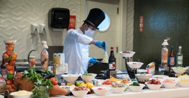 A chef wearing protective gear against the COVID-19 pandemic presents food in an open buffet food service in a restaurant in Antalya, southern Turkey, June 22, 2020. (Shutterstock Photo)