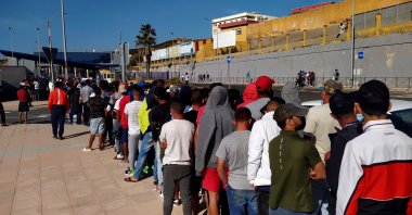 Moroccan migrants wait in a long line in front of Asylum and Refuge Office at Tarajal border crossing in Ceuta, Spanish enclave in northern Africa, June 2, 2021.  (EPA/Reduan Dris)
