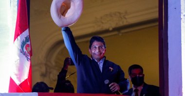 Peru's left-wing presidential candidate Pedro Castillo of the Peru Libre party, gestures to his supporters from the balcony of his party headquarters in Lima, Peru, June 10, 2021. (AFP Photo)