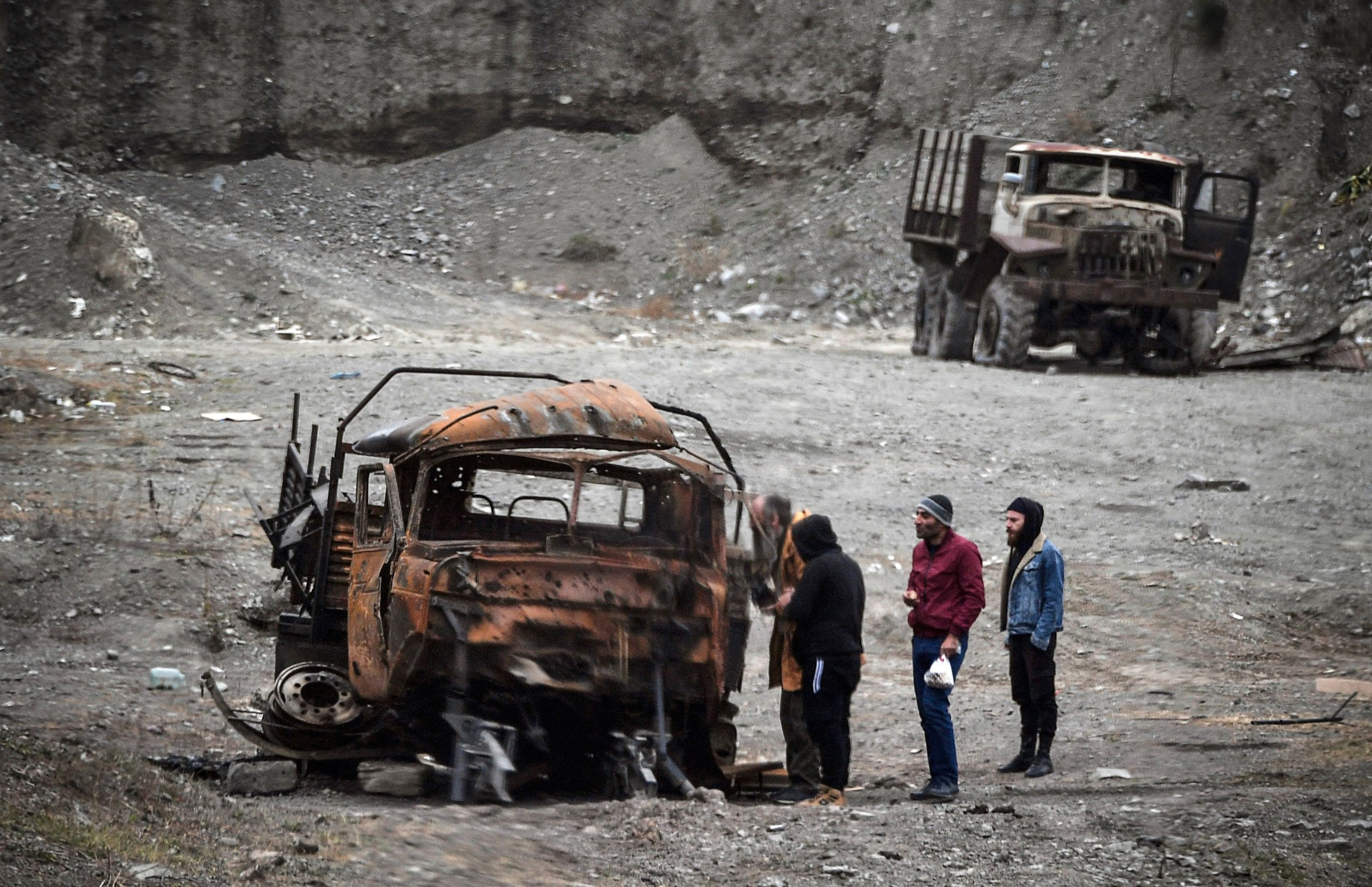 Men inspect a burnt military truck outside Stepanakert, Azerbaijan, Nov. 12, 2020. (AFP)