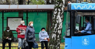 People wearing protective facemasks, amid the coronavirus disease ( COVID-19) pandemic, prepare to board a bus in Moscow, Russia, Nov. 5, 2020. (AFP Photo)