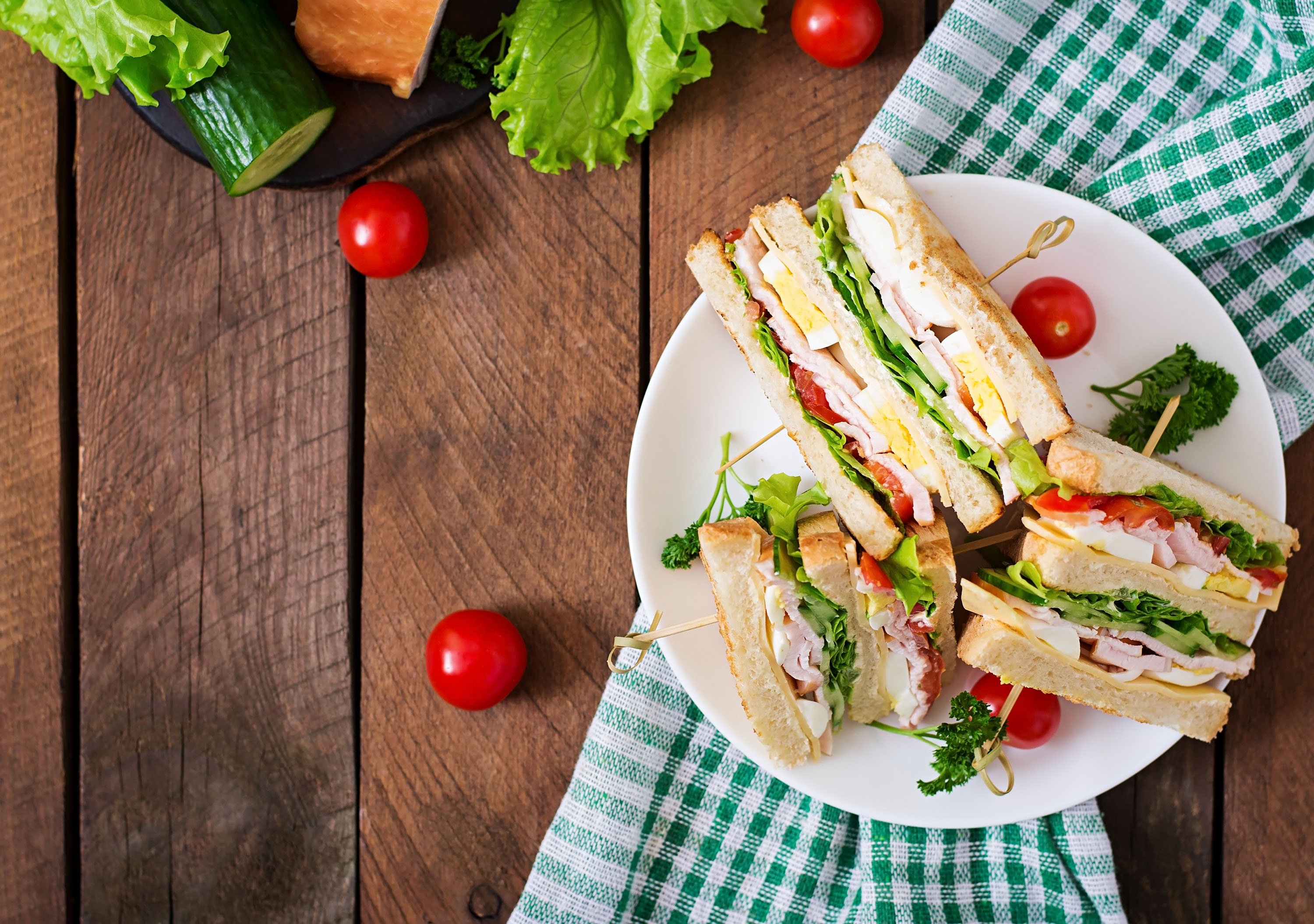 Club sandwich with cheese, cucumber, tomato, ham and eggs. (Shutterstock Photo) 