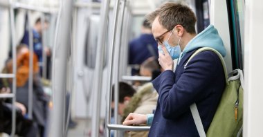 Man wearing protective mask in public transport. (Shutterstock Photo) 