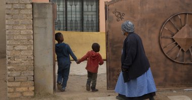 An elderly woman and children enter the property of the home of Gosiame Thamara Sithole in Tembisa, near Johannesburg, South Africa, June 10, 2021. (AP Photo)