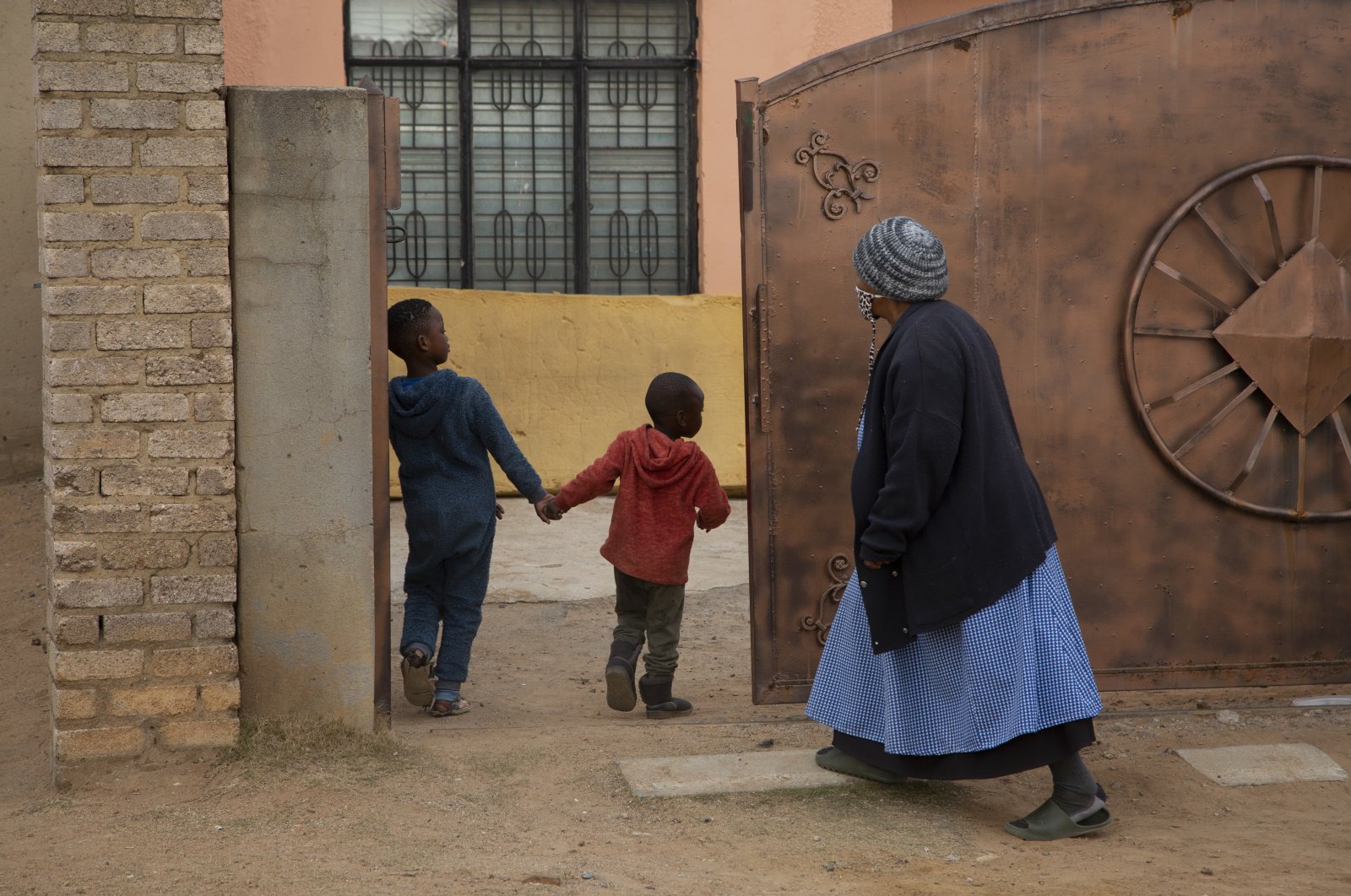 An elderly woman and children enter the property of the home of Gosiame Thamara Sithole in Tembisa, near Johannesburg, South Africa, June 10, 2021. (AP Photo)