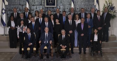 Israeli Prime Minister Naftali Bennett, seated left, President Reuven Rivlin, seated center, and Alternate Prime Minister and Minister of Foreign Affairs Yair Lapid seated right, pose for a group photo with the ministers of the new government at the president's residence in Jerusalem, June 14, 2021. (AP Photo)