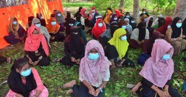 A group of Rohingya refugees, mostly women and children, gather on Pulau Idaman, a small island just off the coast of East Aceh, in northern Sumatra on June 6, 2021, after a group of 81 refugees landed on June 4, in the latest wave of Rohingya arrivals. (AFP Photo)
