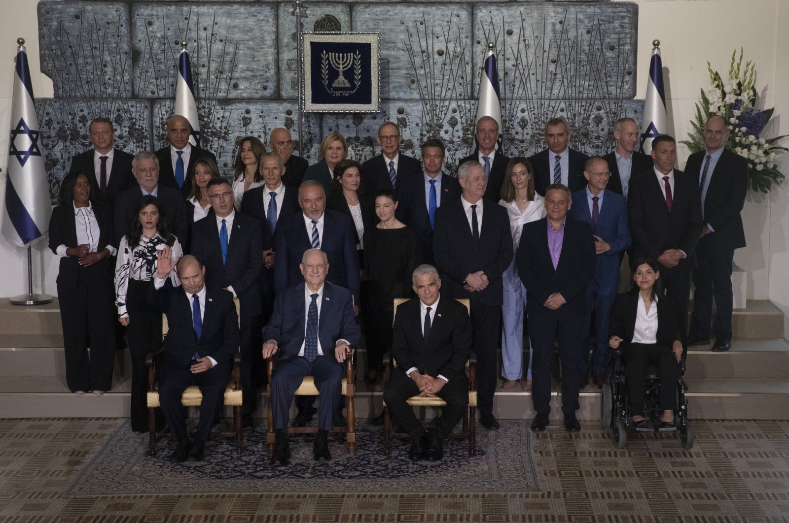 Israeli Prime Minister Naftali Bennett, seated left, President Reuven Rivlin, seated center, and Alternate Prime Minister and Minister of Foreign Affairs Yair Lapid seated right, pose for a group photo with the ministers of the new government at the president's residence in Jerusalem, June 14, 2021. (AP Photo)