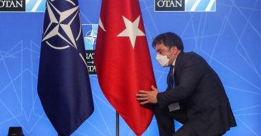 An official adjusts the Turkish flag before a news conference during a NATO summit in Brussels, June 14, 2021. (AFP Photo)