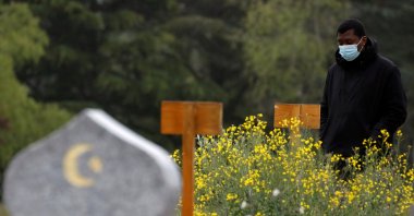 Mamadou Diagouraga, who lost his 71-year-old father Boubou Diagouraga in March 2020 after being infected by COVID-19, stands next to his grave during an interview with Reuters, in the Muslim section of the cemetery in Valenton, near Paris, France, May 6, 2021. (Reuters Photo)