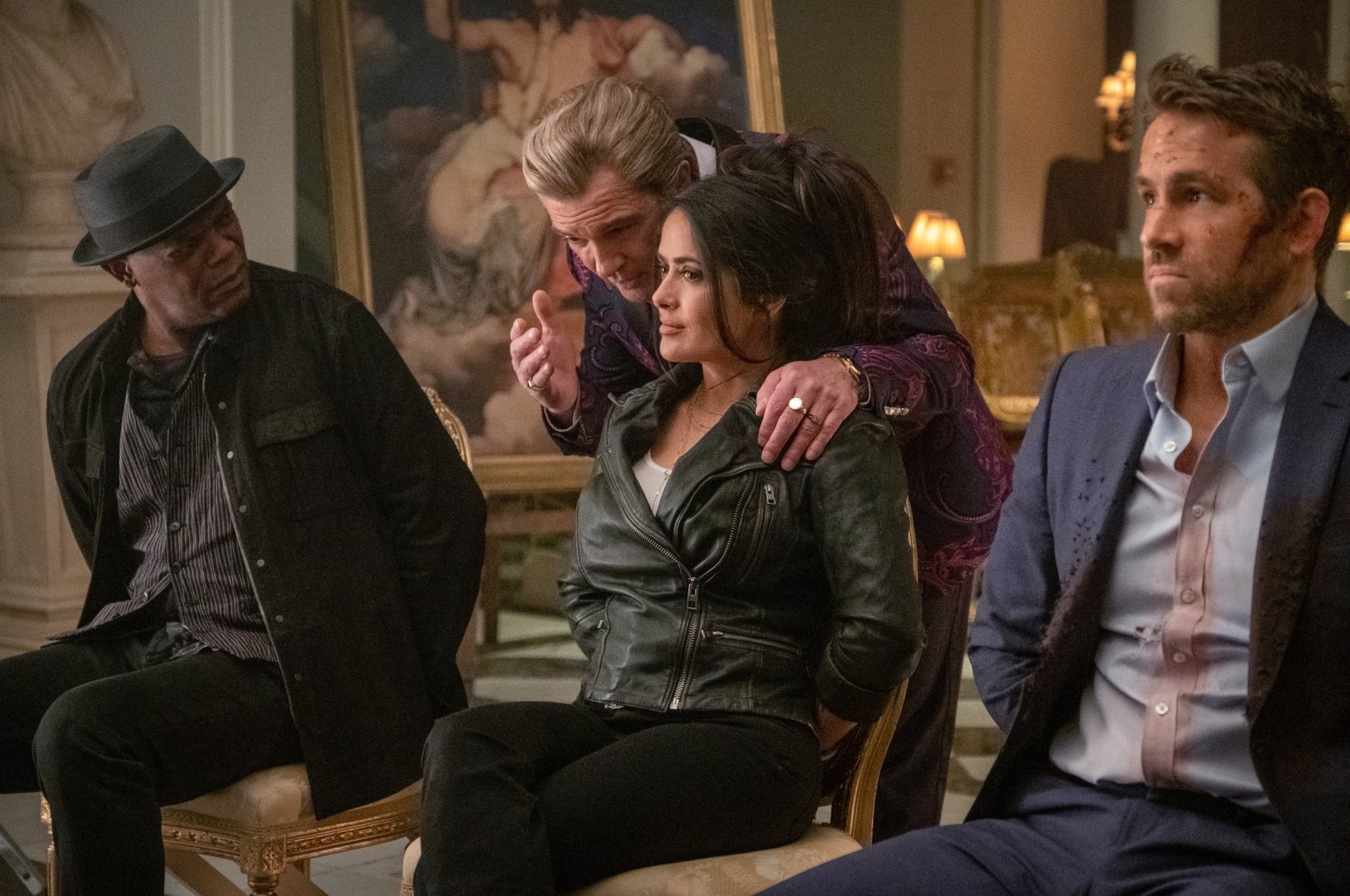 Antonio Banderas (C-L) has a conversation with Samuel L. Jackson (L), Salma Hayek (C-R) and Ryan Reynolds (R) in a scene from the movie, "The Hitman's Wife's Bodyguard." (Lionsgate via AP)