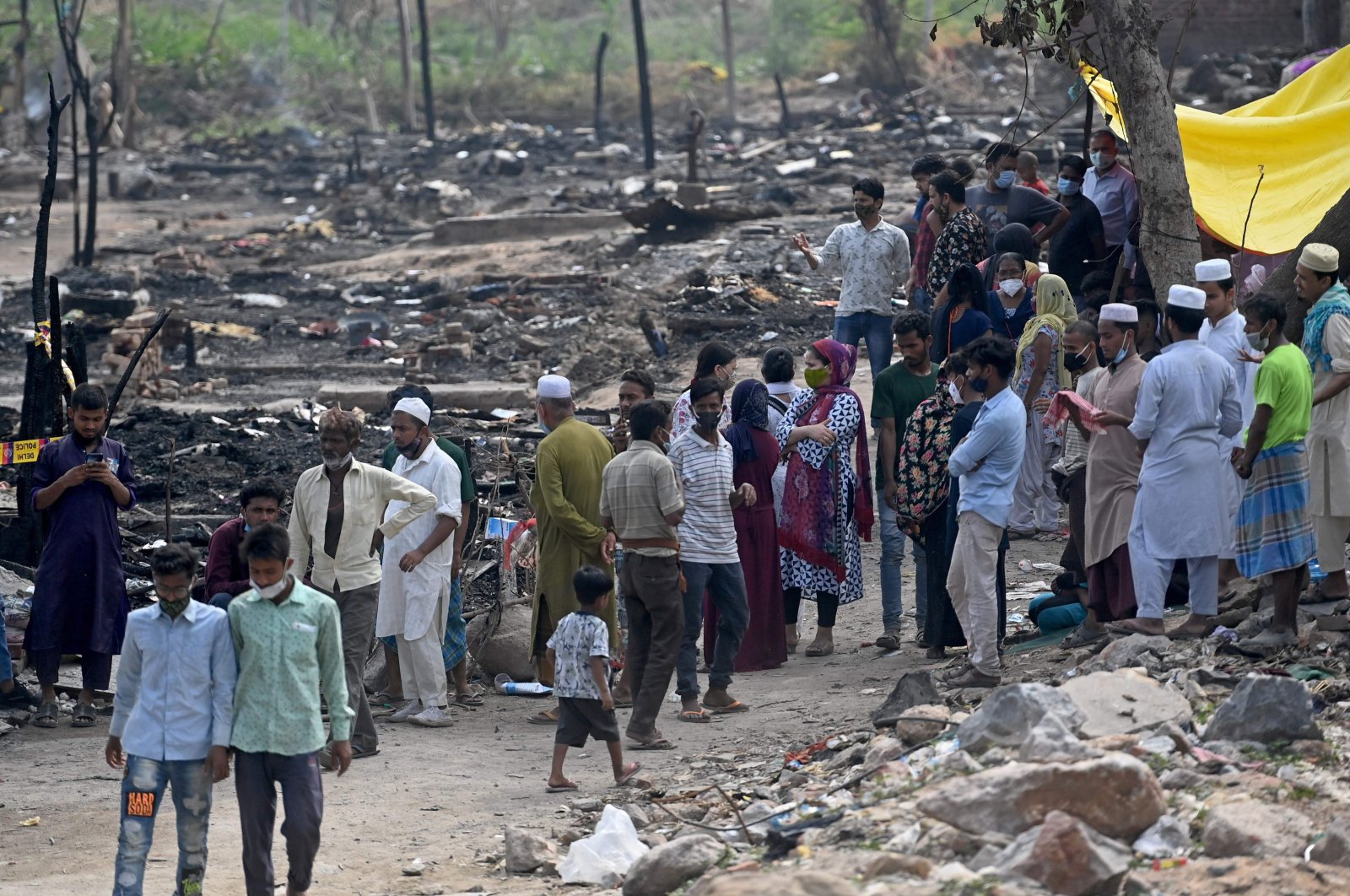 Rohingya refugees gather near the charred remains of their camp after a fire earlier in the day, New Delhi, India, June 13, 2021. (AFP Photo)
