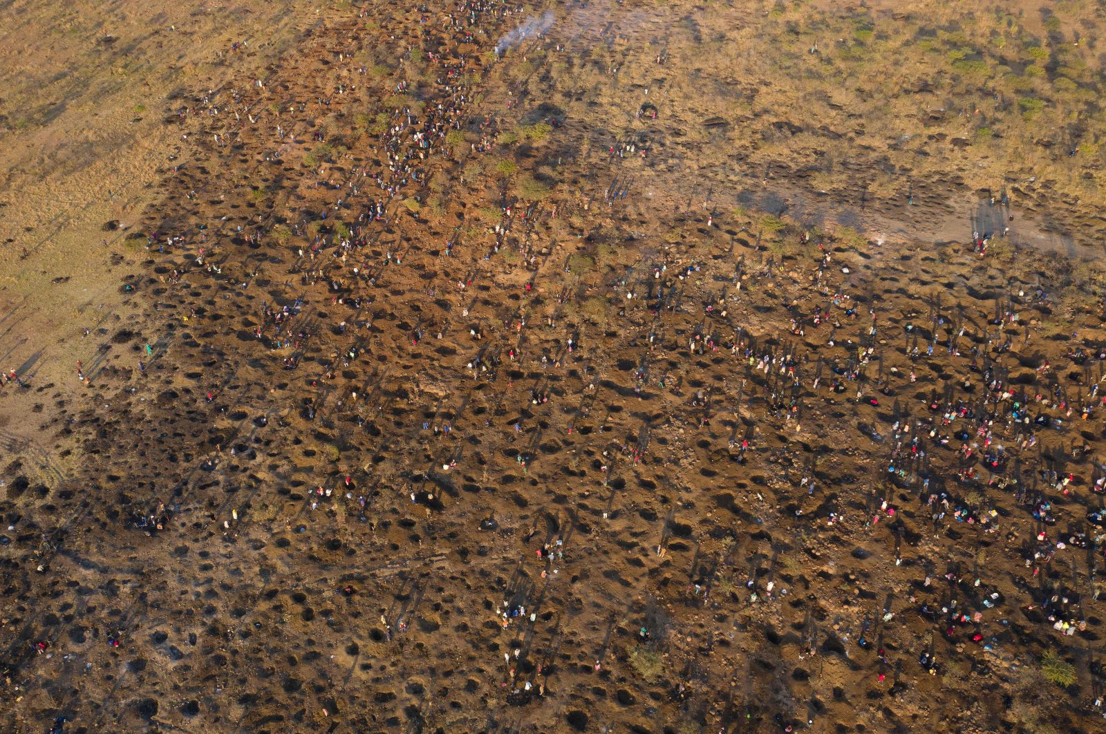 An aerial view shows people digging as they search for what they believe to be diamonds after the discovery of unidentified stones in KwaHlathi village near Ladysmith in KwaZulu Natal, South Africa, June 15, 2021. (AFP Photo)