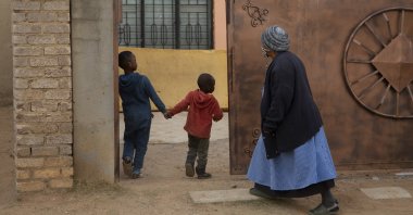 An elderly woman and children enter the property of the home of Gosiame Thamara Sithole in Tembisa, near Johannesburg, South Africa, June 10, 2021. (AP Photo)