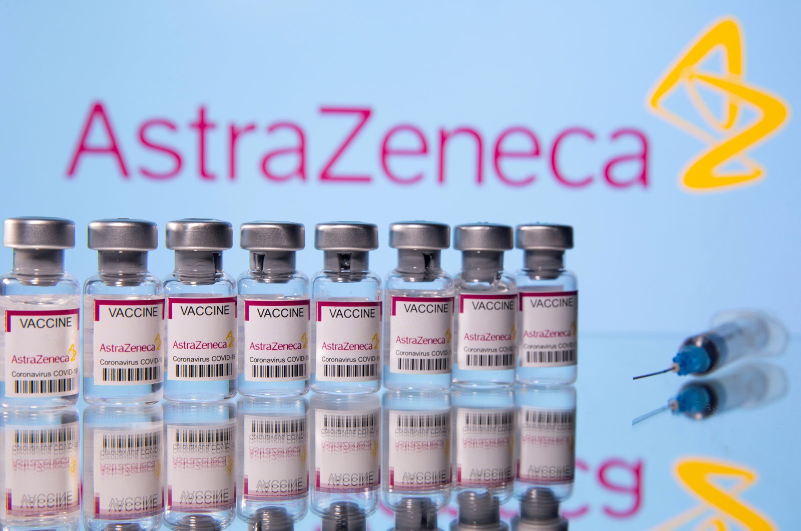 Vials labelled "Astra Zeneca COVID-19 Coronavirus Vaccine" and a syringe are seen in front of a displayed AstraZeneca logo, March 14, 2021. (Reuters Photo)