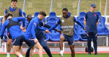 England forward Raheem Sterling (R) and England's defender John Stones (C) fight for a ball with teammates during a training session at the Tottenham Hotspur training ground, London, England, June 17, 2021. (AFP Photo)