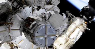 French astronaut Thomas Pesquet (T-C), and NASA astronaut Shane Kimbrough venture out on a spacewalk to outfit the International Space Station with powerful, new solar panels to handle the growing electrical demands from upcoming visitors, June 16, 2021. (NASA via AP)
