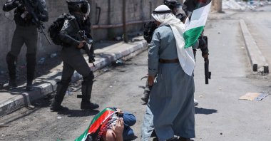 A Palestinian protester lies on the ground after being pushed by Israeli security forces amid clashes following a demonstration against Israeli settlements in the village of Beita, south of Nablus in the occupied West Bank, Palestine, June 18, 2021. (AFP Photo)