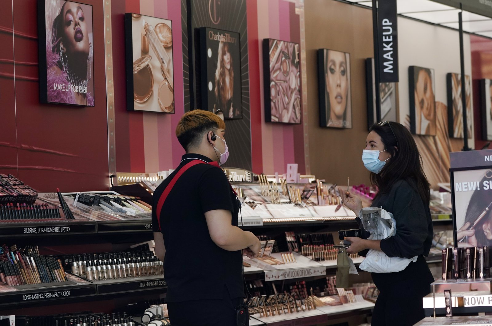 A worker (L), tends to a customer at a cosmetics shop amid the COVID-19 pandemic in Los Angeles, California, U.S., May 20, 2021. (AP Photo)