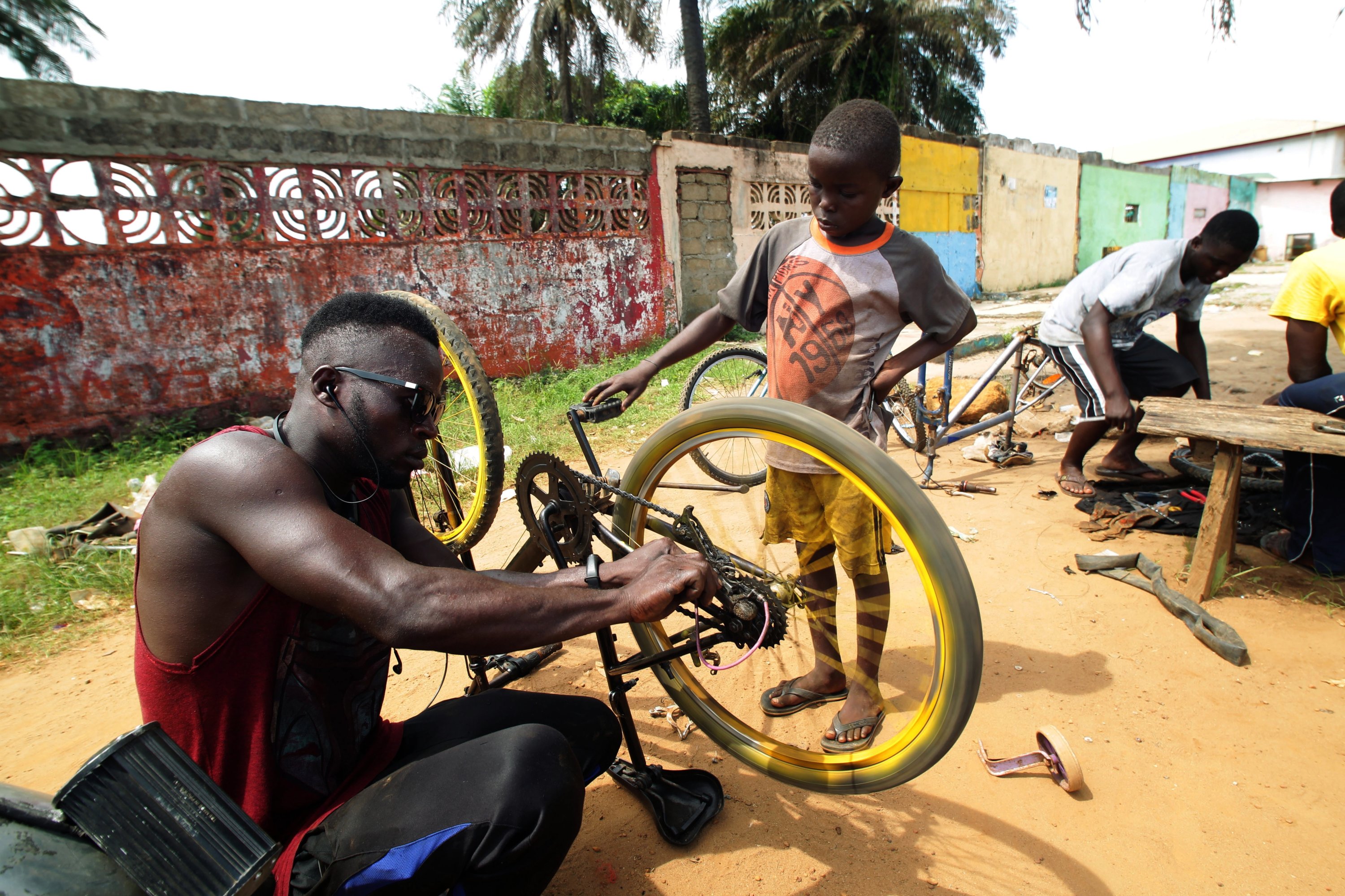 Odixco F. Gongar (L), the owner of God Bless Bicycle Repair Center, repairs a bicycle as one of his trainees, Jonathan Jacobs, looks on in Paynesville, outside Monrovia, Liberia, May 24, 2021.  (EPA)