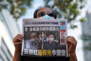 A supporter holds a copy of the anti-Beijing Apple Daily newspaper during a court hearing after police charged two executives of the newspaper under a national security law, outside West Magistrates’ Courts in Hong Kong, China, June 19, 2021. (Reuters Photo)