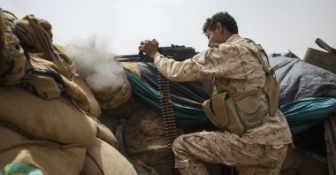 A Yemeni fighter backed by the Saudi-led coalition fires his weapon on the front lines of Marib, Yemen, June 19, 2021. (AP Photo)