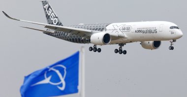 An Airbus A350 jetliner flies over Boeing flags as it lands after a flying display during the 51st Paris Air Show at Le Bourget airport near Paris, France, June 15, 2015. (Reuters Photo)