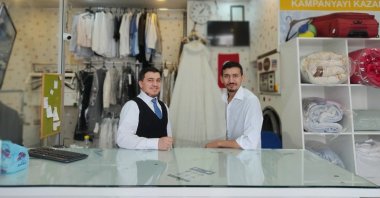 Brothers Mohammed and Ahmed Mulla stand behind the counter at their dry cleaning center in the capital Ankara, Turkey, June 19, 2021. (AA Photo)