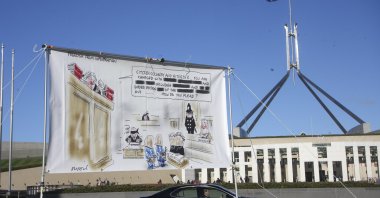 A protest banner hangs outside Parliament House in the Australian capital during a protest against the prosecution of lawyer Bernard Collaery. Critics of the secret prosecutions of a former Australian spy and his lawyer argue they are another example of a government concealing political embarrassment under the guise of national security, June 17, 2021, Canberra, ACT, Australia. (AP Photo)