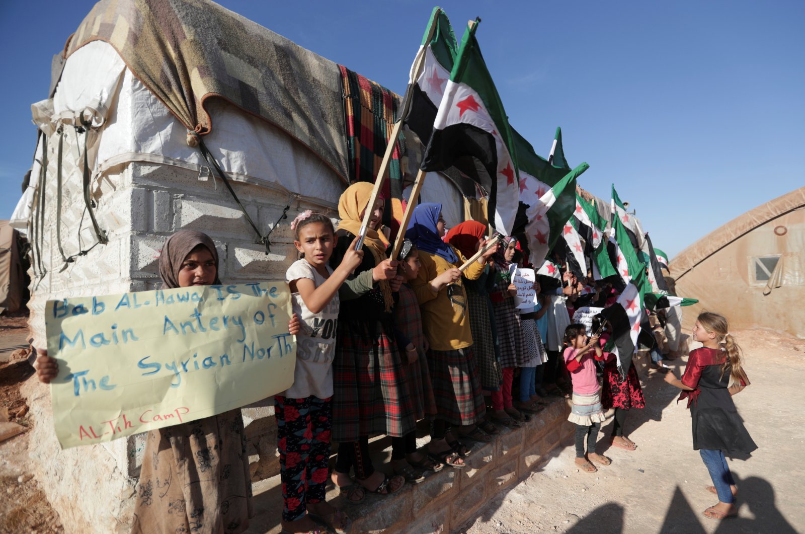 An internally displaced Syrian girl holds a sign during a protest against the closure of Bab al-Hawa crossing in the opposition-held Idlib, northwestern Syria, June 7, 2021. (REUTERS Photo)