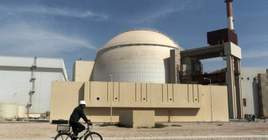 A worker rides a bicycle in front of the reactor building of the Bushehr nuclear power plant, just outside the southern city of Bushehr, Iran, Oct. 26, 2010. (AP Photo)