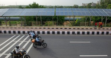 Bikers pass near solar panels installed on Delhi Meerut expressway, New Delhi, India, June 15, 2021. (Shutterstock Photo)