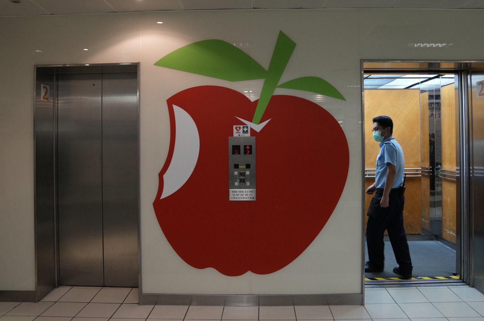 A security guard uses a lift at the Apple Daily headquarters at the printing house in Hong Kong, China, June 17, 2021. (AP Photo)