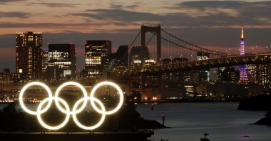 A long-exposure photo of the Olympic Rings on a floating platform with the Rainbow Bridge in the background ahead of the Tokyo 2020 Olympic Games, Tokyo, Japan June 21, 2021. (Reuters Photo)