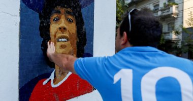 A man touches a mosaic made by the cultural organization Comando Maradona as a homage to late Argentine soccer superstar Diego Armado Maradona, Buenos Aires, Argentina, Feb. 25, 2021. (Reuters Photo)