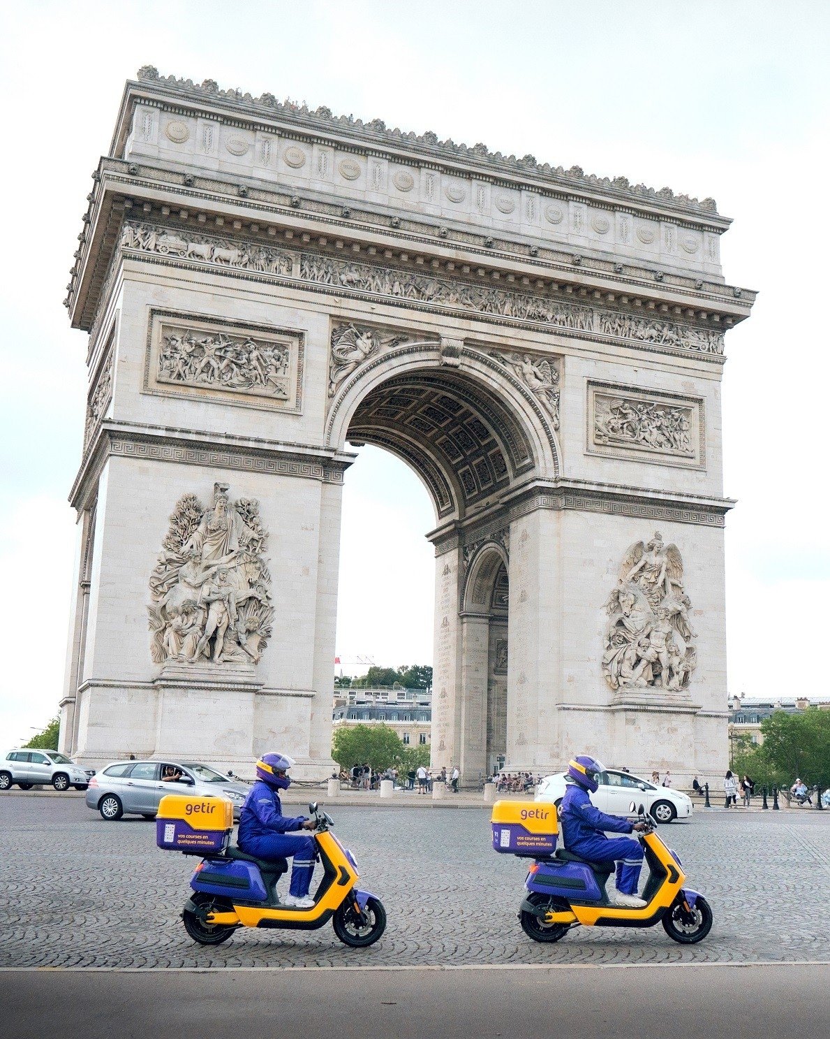 Getir couriers pass by the Arc de Triomphe on Champs Elysees avenue in Paris, France, June 22, 2021. (IHA Photo)
