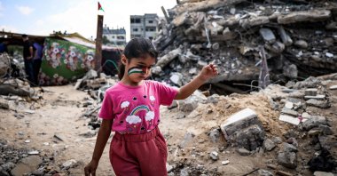 A Palestinian girl with a national flag painted on her face plays amidst the rubble of buildings destroyed by last month's Israeli bombardment of the Gaza Strip, in Beit Lahia, Palestine, June 19, 2021. (AFP Photo)