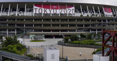 A worker walks through the front entrance of National Stadium, Tokyo, Japan, June 23, 2021. (AP Photo)