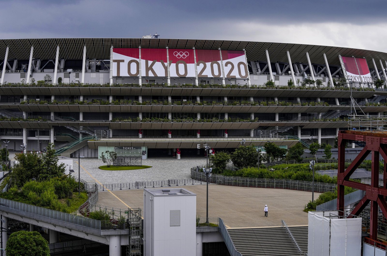 A worker walks through the front entrance of National Stadium, Tokyo, Japan, June 23, 2021. (AP Photo)