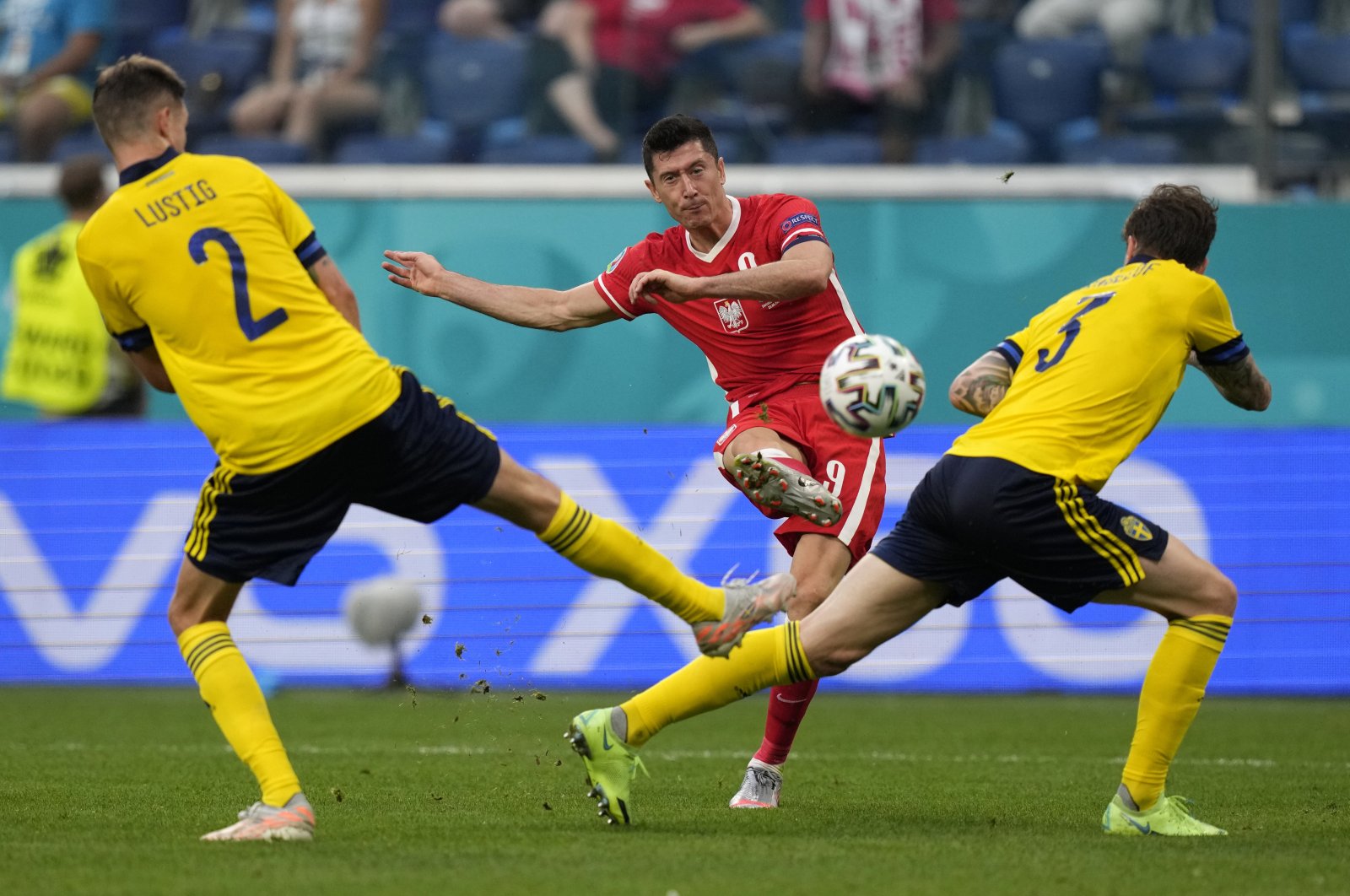 Poland's Robert Lewandowski (C), shoots to score past Sweden's Victor Lindeloef and Sweden's Mikael Lustig during the Euro 2020 football championship Group B match between Sweden and Poland at Saint Petersburg stadium in St. Petersburg, Russia, Wednesday, June 23, 2021. (AP Photo)