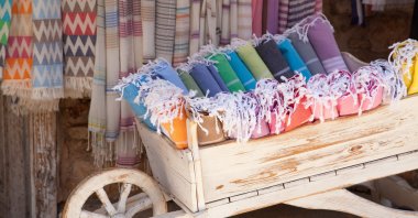 Multicolored Turkish bath towels in a wooden cart. (Shutterstock Photo)