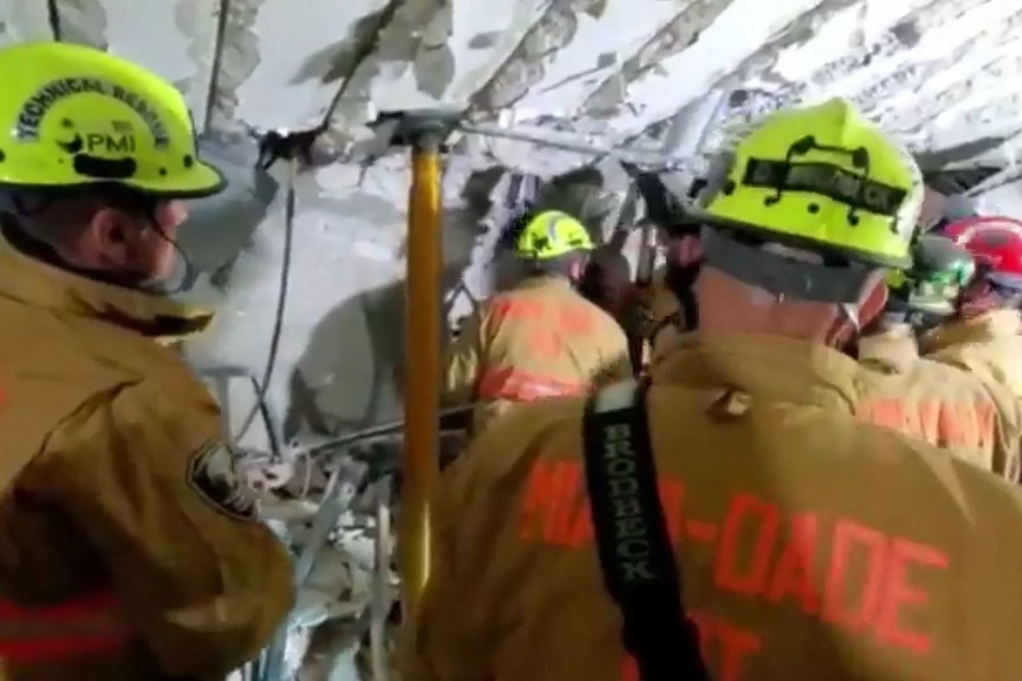 This handout video grab taken from a video posted by the Miami-Dade Fire Rescue shows firefighters working in the basement parking garage at Champlain Towers after the partial collapse of the building in Surfside, north of Miami Beach, U.S., June 24, 2021. (Miami-Dade fire rescue/ AFP Photo)