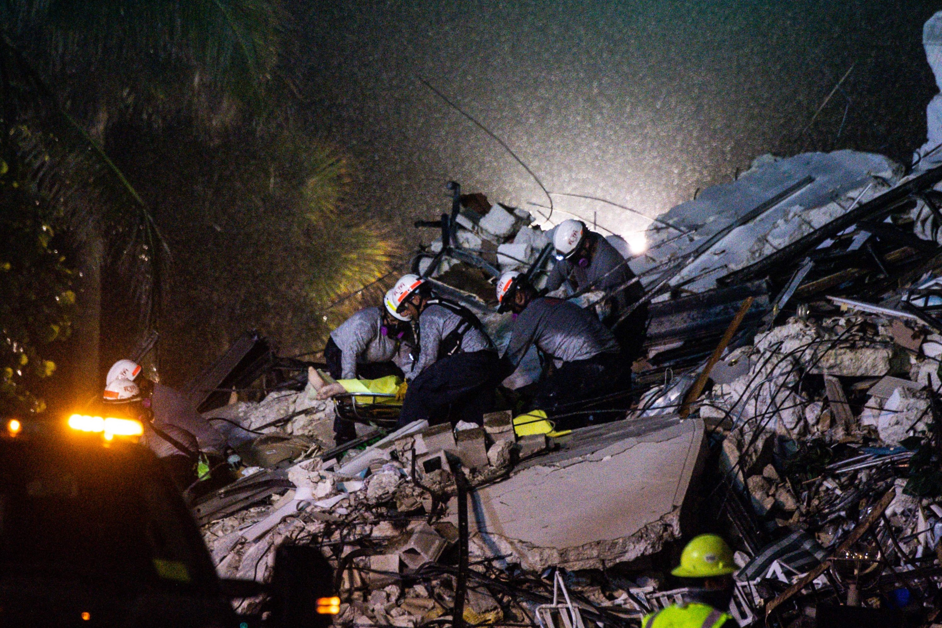 Search and Rescue personnel pull a body out of the rubble after the partial collapse of the Champlain Towers South in Surfside, north of Miami Beach, June 24, 2021. (AFP Photo)